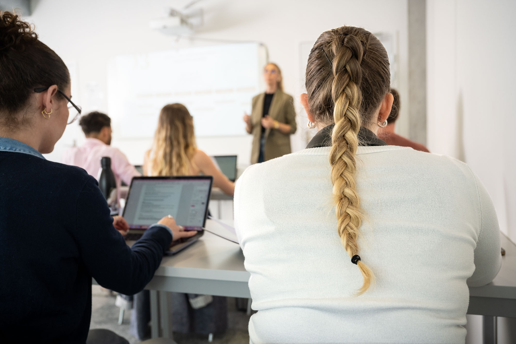 Étudiants de dos attentifs dans une salle de classe à Rocket School